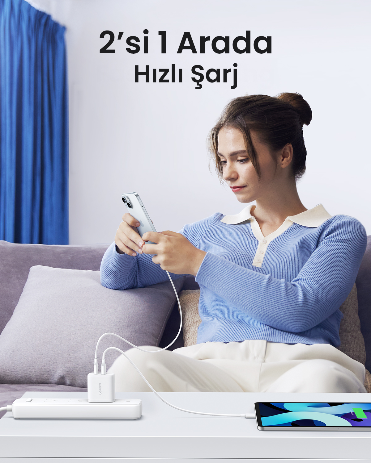 Bir kadın kanepede oturuyor, şarj cihazına bağlı bir telefon kullanıyor. Bir tablet masada duruyor. Metin: 2'si 1 Arada Hızlı Şarj.