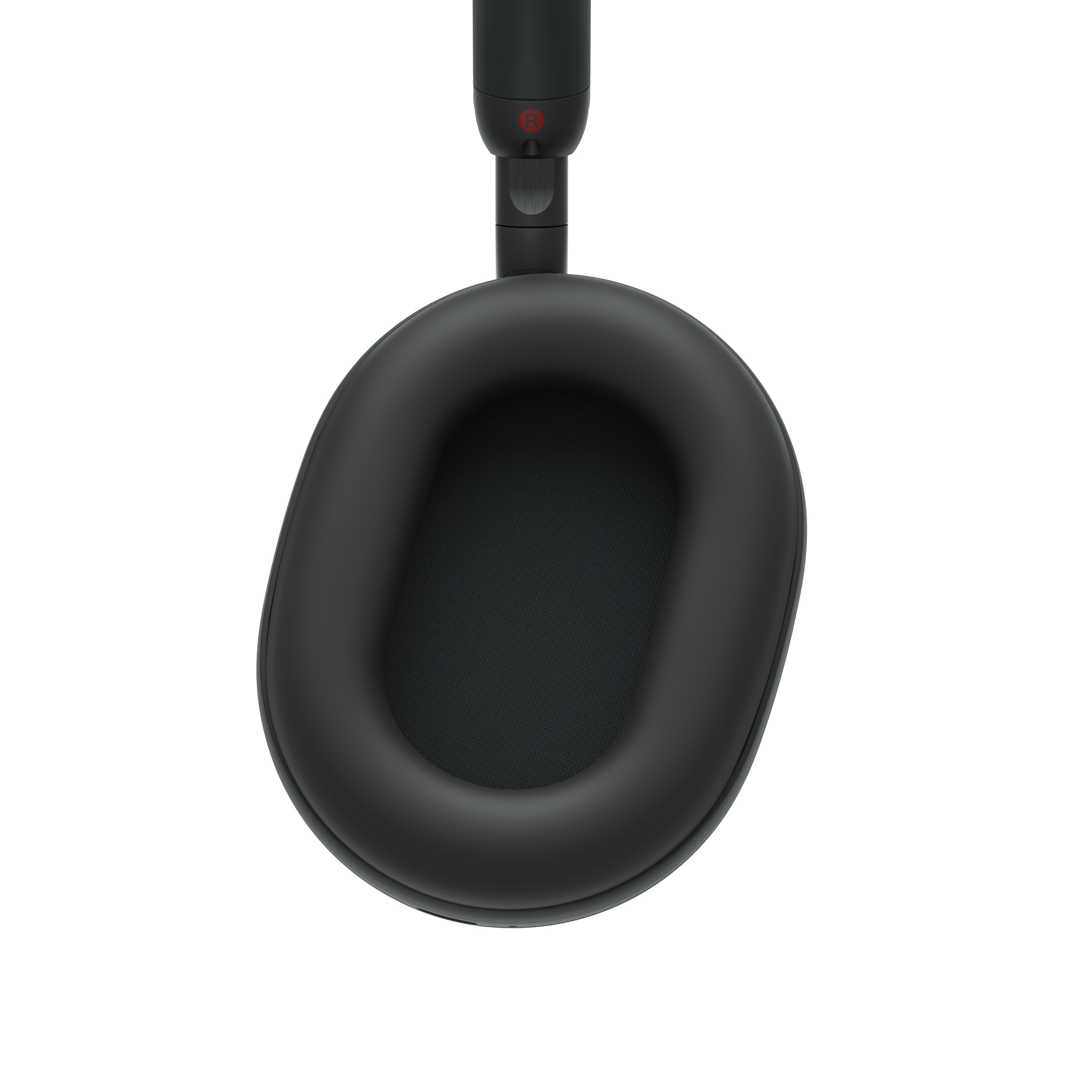 Auriculares negros, almohadilla ovalada con malla interior, vista superior. Fondo blanco.