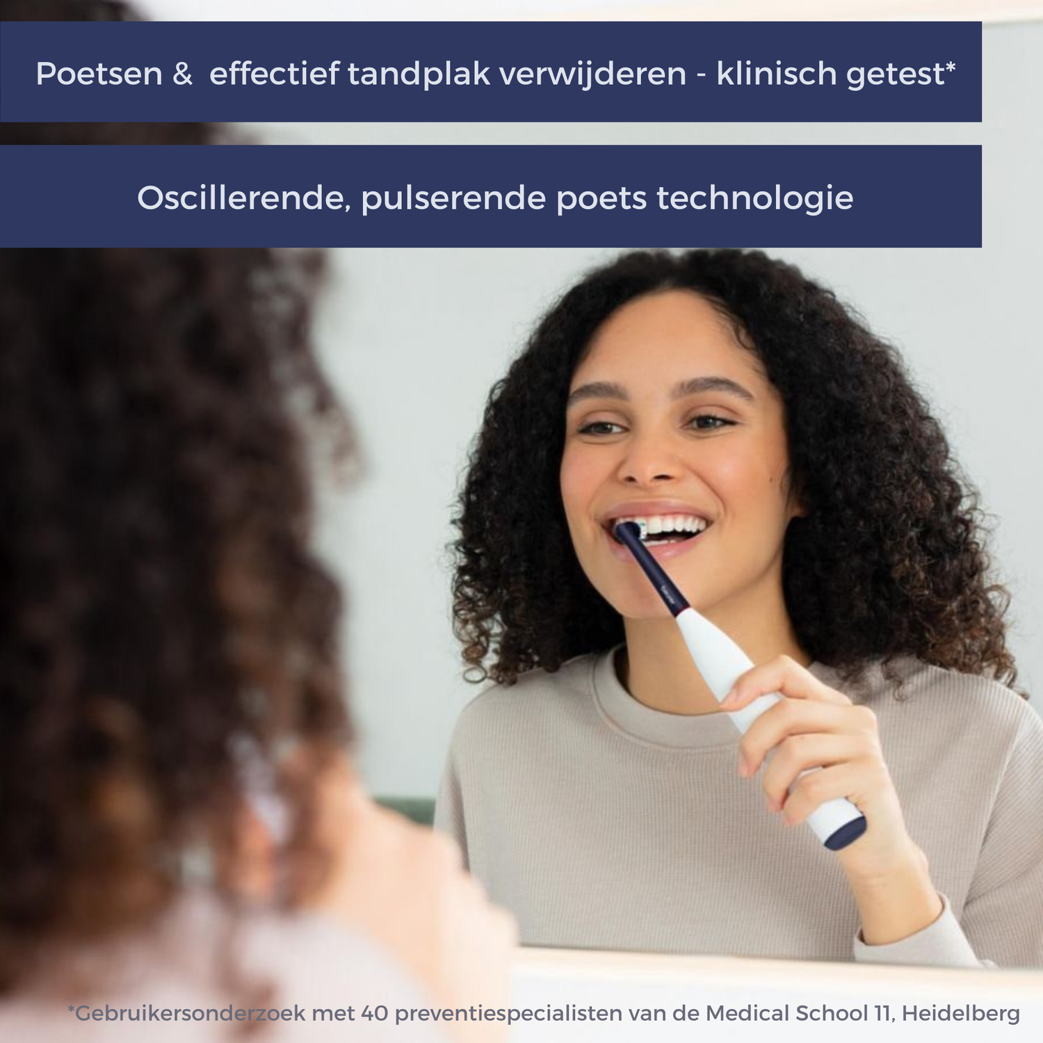 A woman smiles while brushing her teeth with an electric toothbrush in front of a mirror. The text at the top says 'Brush & remove plaque'.