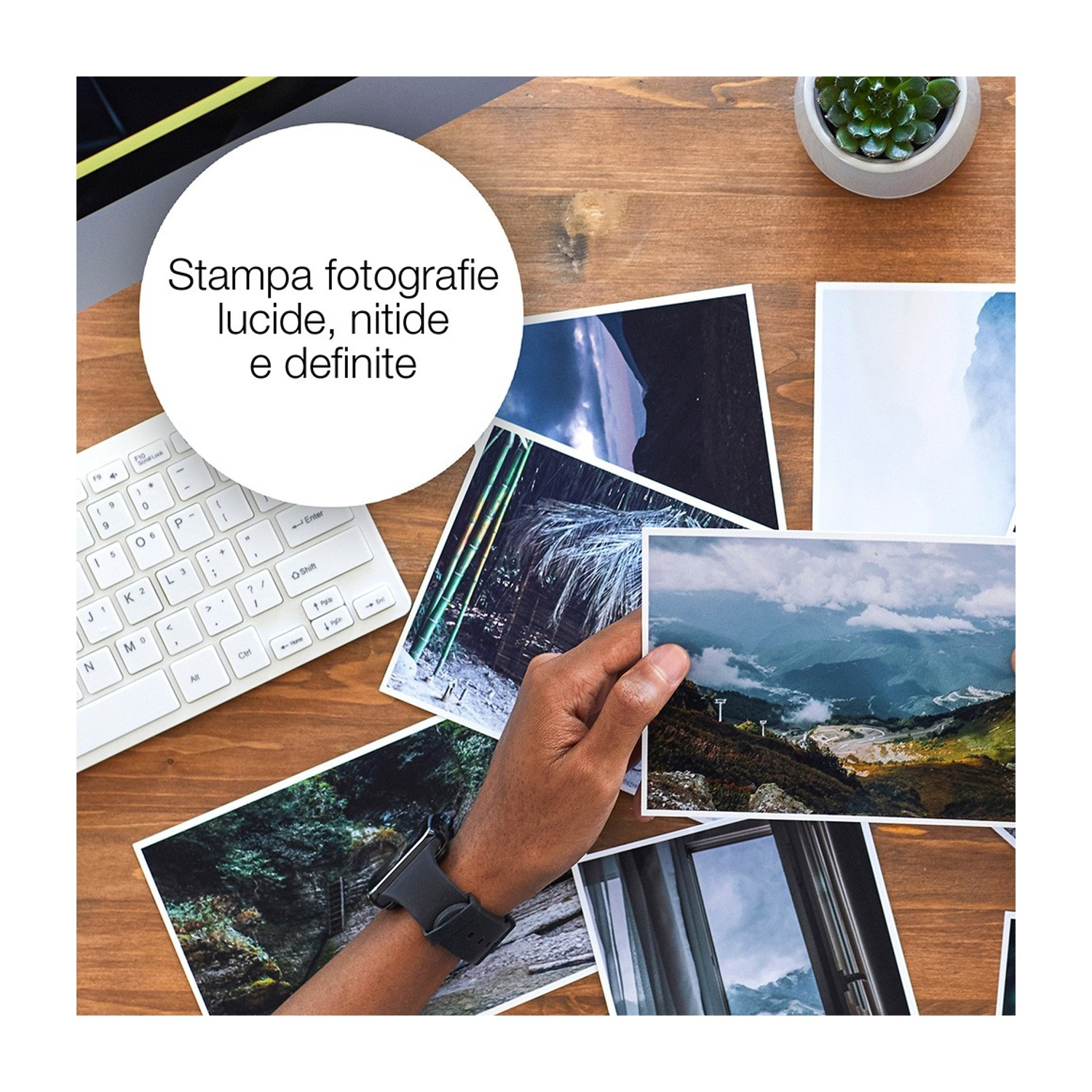 Una mano tiene in mano una foto di montagne. Altre foto, tastiera, orologio e pianta su una superficie di legno. Testo in un cerchio bianco.