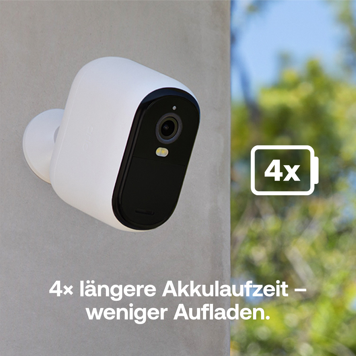 Eine weiße Überwachungskamera mit schwarzer Front ist an einer grauen Wand befestigt. Ein Batteriesymbol zeigt 4x Akkulaufzeit.