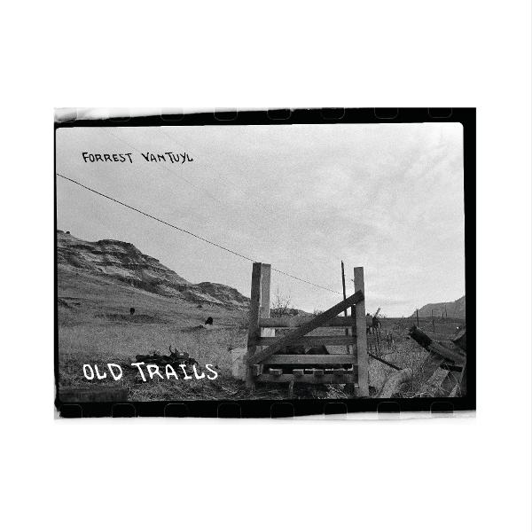 Schwarz-Weiß-Foto eines Holztores auf einem Feld. Hügel und Himmel im Hintergrund. Text: 'Old Trails' und 'Forrest Van Tuyl'.