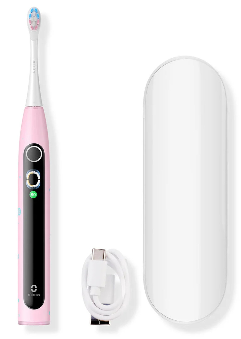 Różowa elektryczna szczoteczka do zębów, białe etui i kabel USB-C na białym tle.