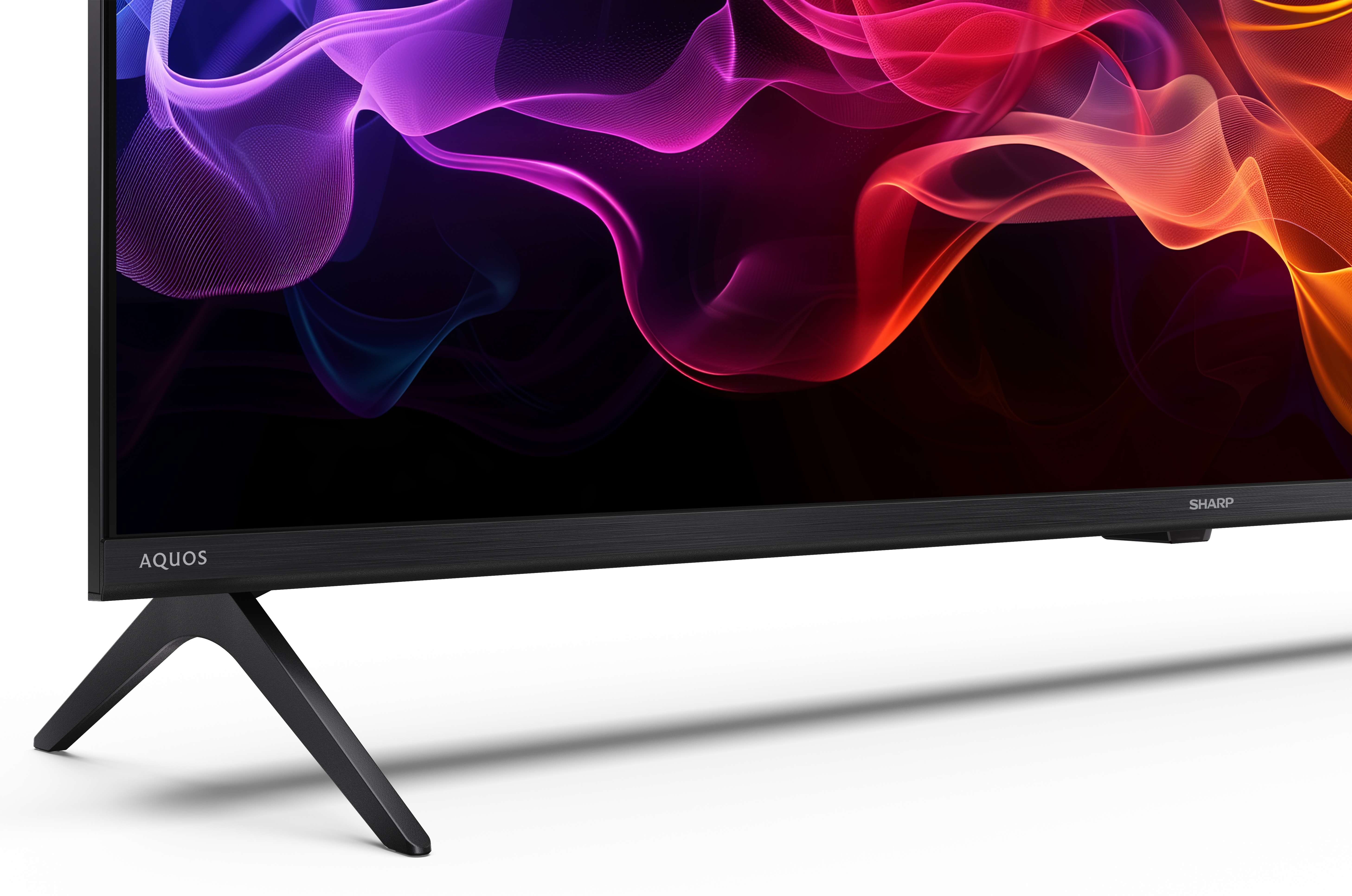 Czarny telewizor Sharp Aquos z abstrakcyjnymi, kolorowymi kształtami na ekranie. Telewizor jest na białym tle.