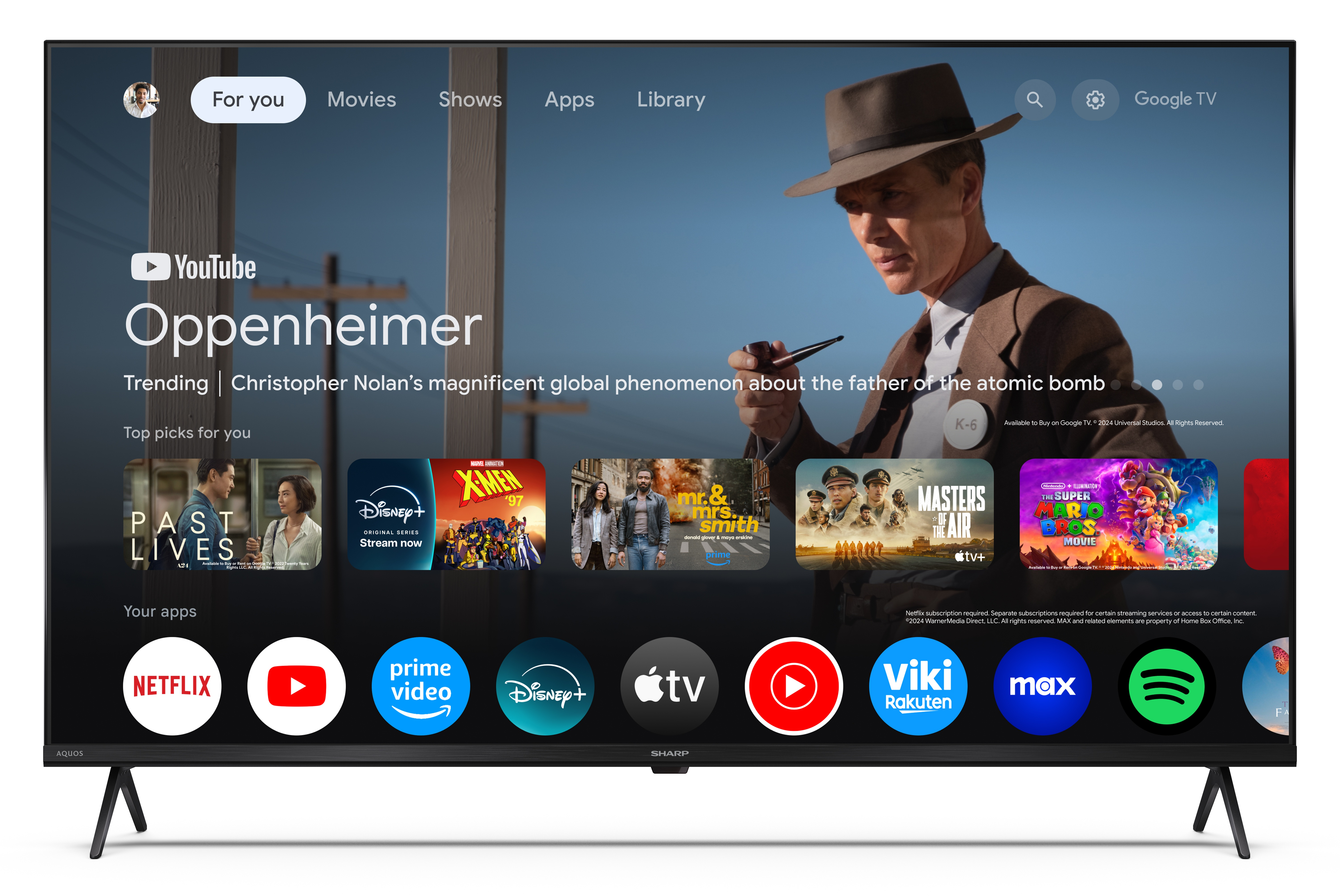 Telewizor Sharp wyświetla interfejs Google TV. Ekran pokazuje 'Oppenheimer' i ikony aplikacji filmowych, jak Netflix i YouTube.