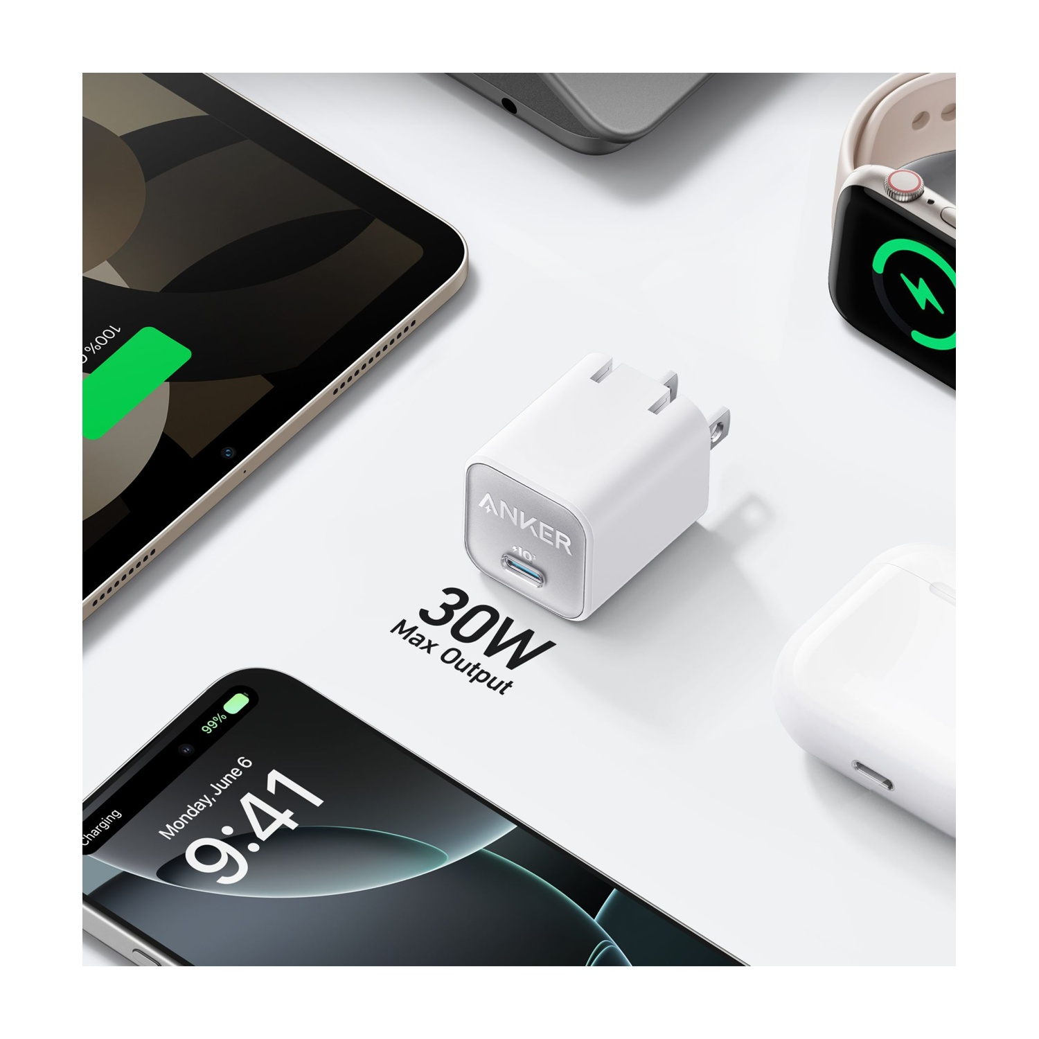 Un caricatore Anker bianco, un telefono, un tablet, un Apple Watch e auricolari sono in mostra. Il telefono mostra le 9:41 e il 99% di batteria. Tablet al 100%.