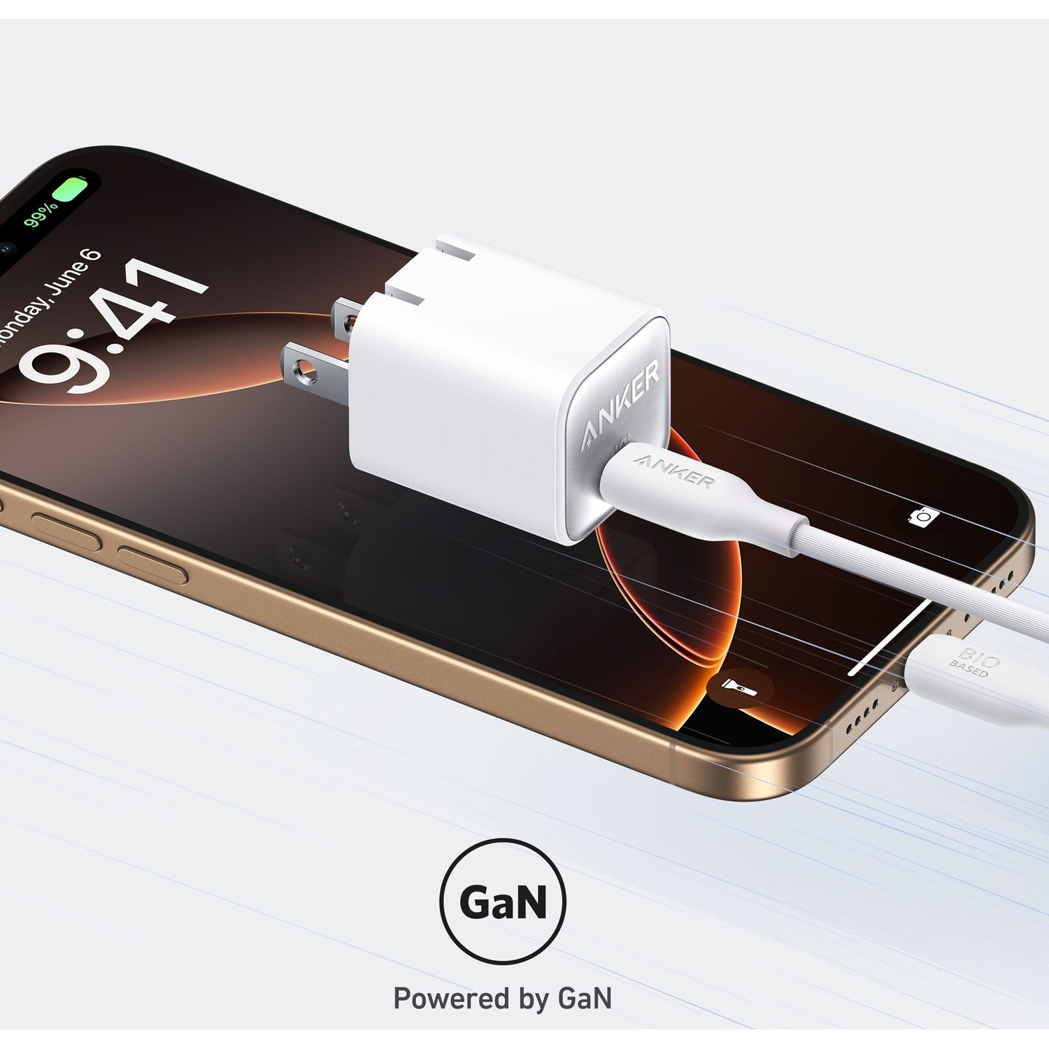 Un iPhone è in carica con un caricabatterie Anker. Il caricabatterie è bianco, collegato al telefono e lo sfondo è bianco.