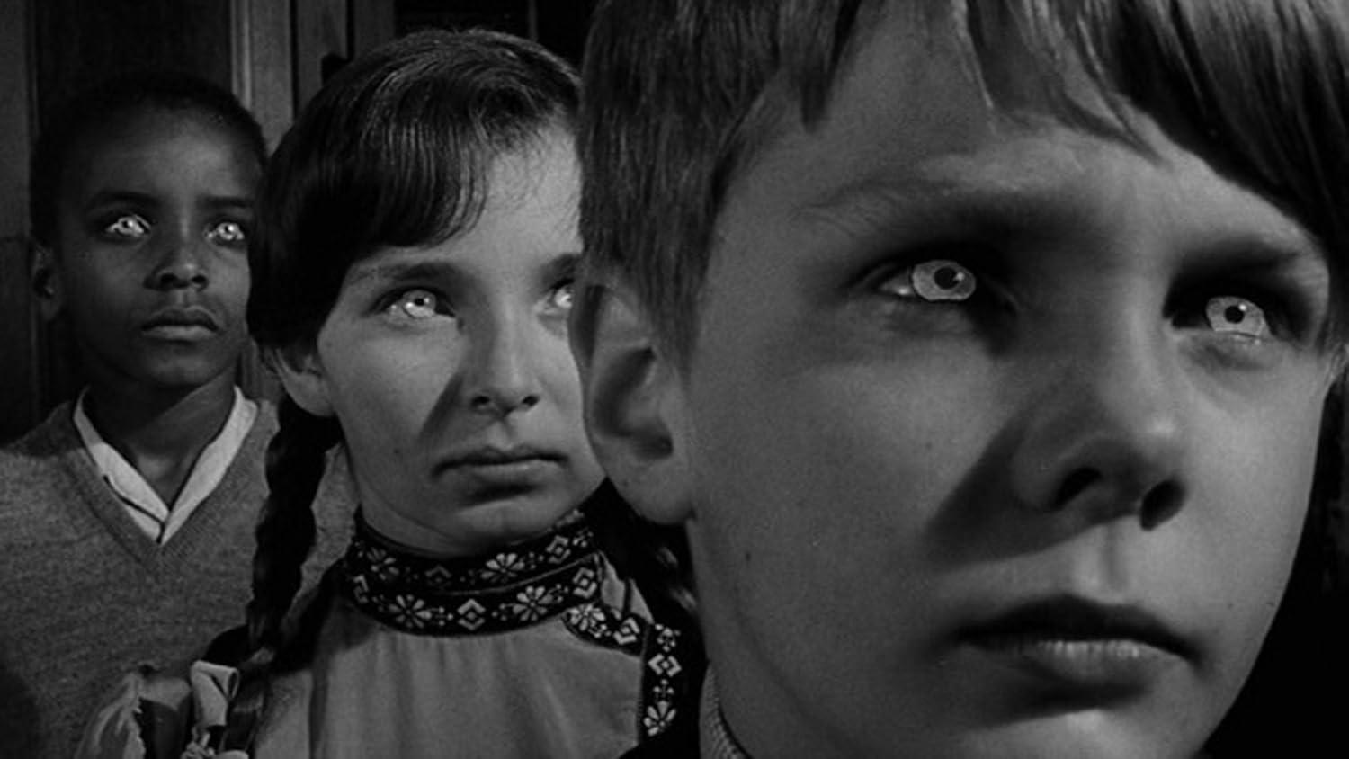 Schwarz-Weiß-Bild zeigt drei Kinder mit leuchtend weißen Augen. Ein Kind ist im Fokus, andere im Hintergrund unscharf.