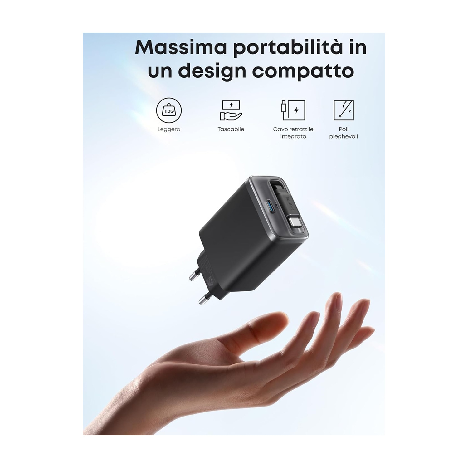 Un caricabatterie nero è tenuto in una mano. Il caricabatterie è etichettato con testo in italiano: Massima portabilità. Lo sfondo è azzurro.