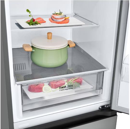 Otwarta lodówka z daniami na półkach. Łosoś, garnek i steki w środku. Szuflada Fresh Zone na dole.