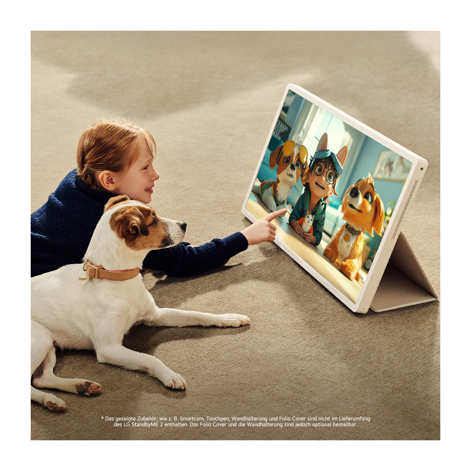 Ein Mädchen und ein Hund schauen auf ein Tablet mit Zeichentrickhunden. Der Hund ist weiß und braun. Sie sitzen auf einem braunen Teppich.