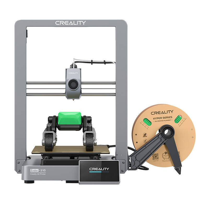 Egy szürke Creality Ender-3 V3 3D nyomtató. Egy filamentszál és egy fekete tartó jobbra. Zöld blokk van a nyomtatón.