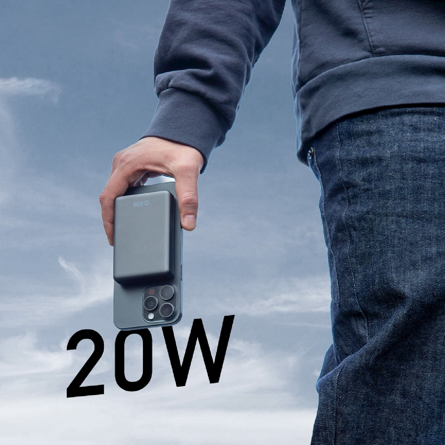 Una persona tiene in mano un telefono con un power bank collegato. Il testo '20W' è visibile in basso. Sfondo del cielo.