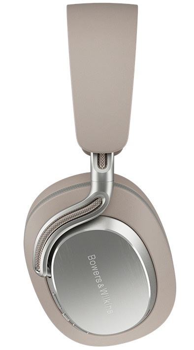 Beżowe słuchawki Bowers & Wilkins. Muszle są owalne. Pałąk jest wysunięty. Widoczne metaliczne akcenty i nazwa marki.