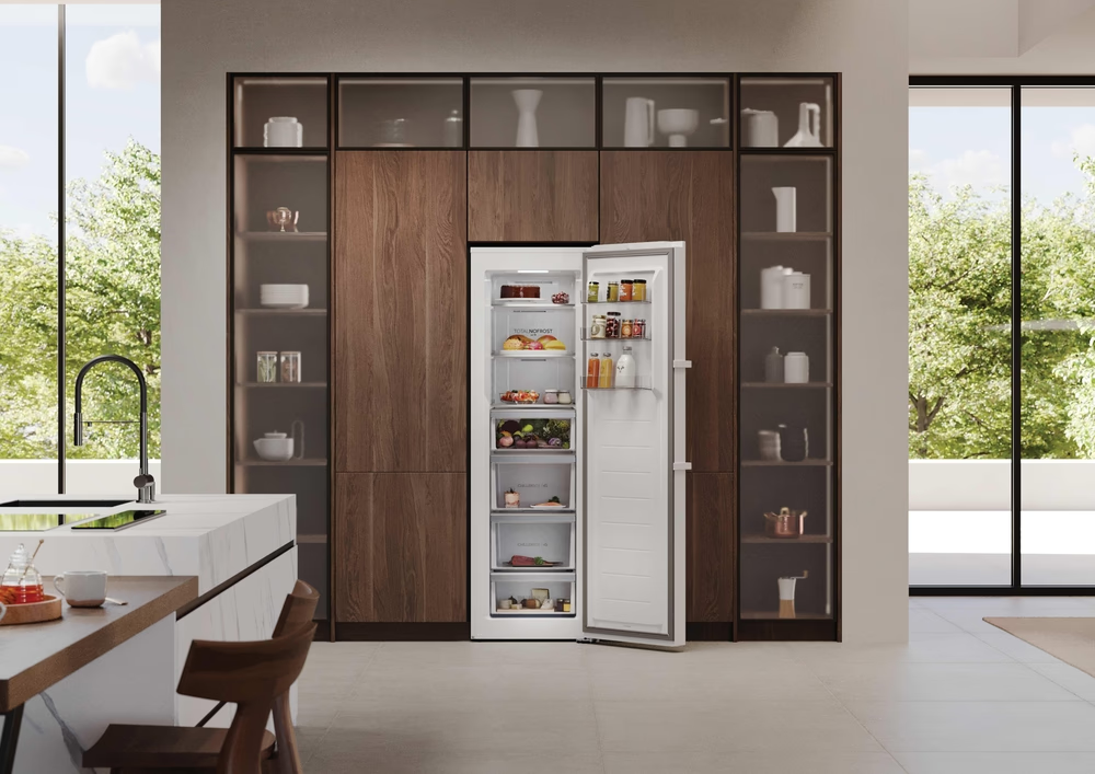 Moderne Küche mit offenem Kühlschrank, Holzschränken und Kochinsel. Obst, Gemüse und Gläser mit Lebensmitteln sind im Kühlschrank sichtbar.