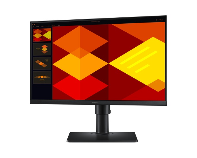 A Samsung monitor piros, narancssárga és sárga rombuszokból álló geometriai mintát jelenít meg. A fekete állvány tartja a képernyőt.