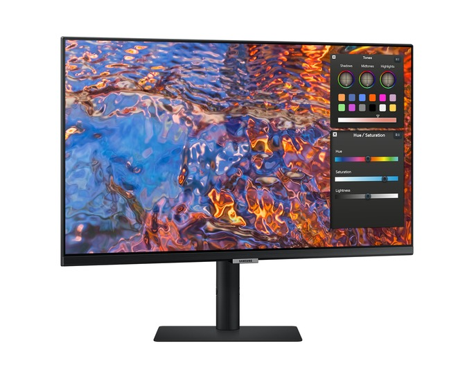 Egy Samsung monitor színes, absztrakt képet jelenít meg. Egy beállítási panelen színbeállítási lehetőségek láthatók. A monitor fekete állványon áll.