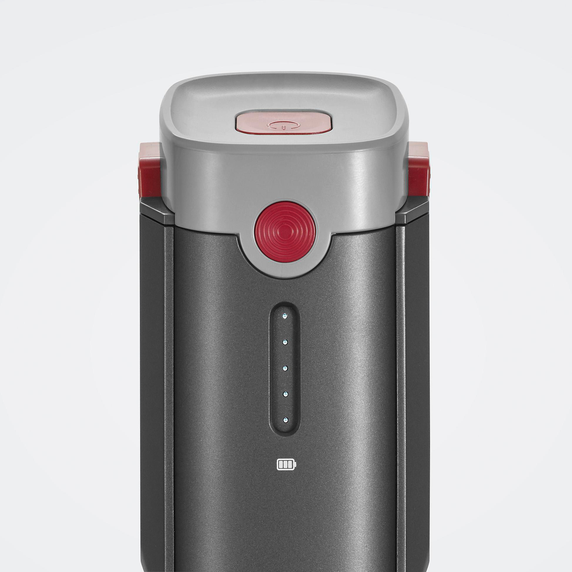 Zylindrisches Gerät mit grauem Gehäuse, roten Akzenten und roter Taste. Es hat vier Kontrollleuchten und ein Batteriesymbol.