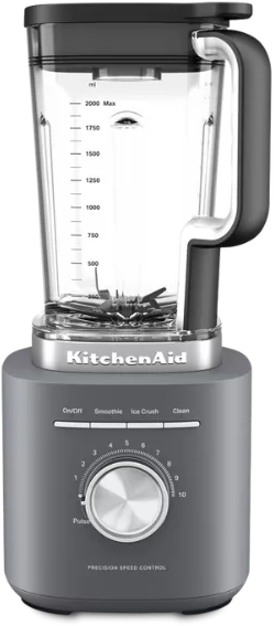 Egy KitchenAid turmixgép. Szürke alappal, átlátszó tartállyal. Van rajta sebességszabályzó tárcsa és gombok a különböző funkciókhoz.