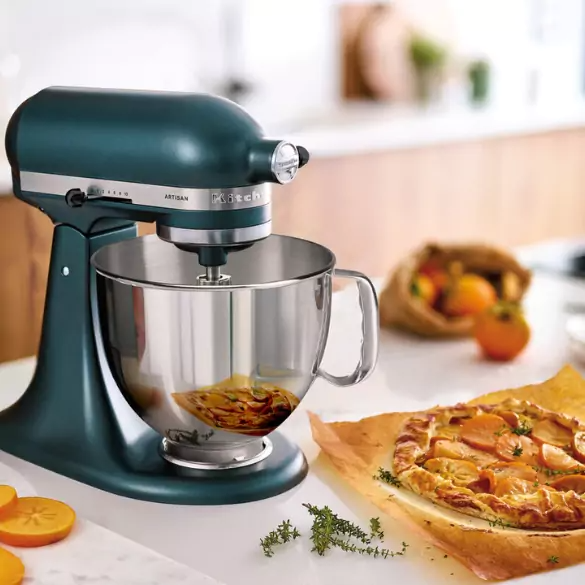 Zöld KitchenAid mixer, rozsdamentes acél tál. Persimmon pite pergamen. Gyümölcstáska. Konyhapult kakukkfűvel és persimmon szeletekkel.