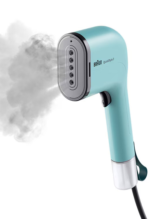 Turkusowa parownica Braun QuickStyle 3. Para wydobywa się z głowicy. Uchwyt jest turkusowy ze srebrną podstawą. Dołączony jest czarny przewód.