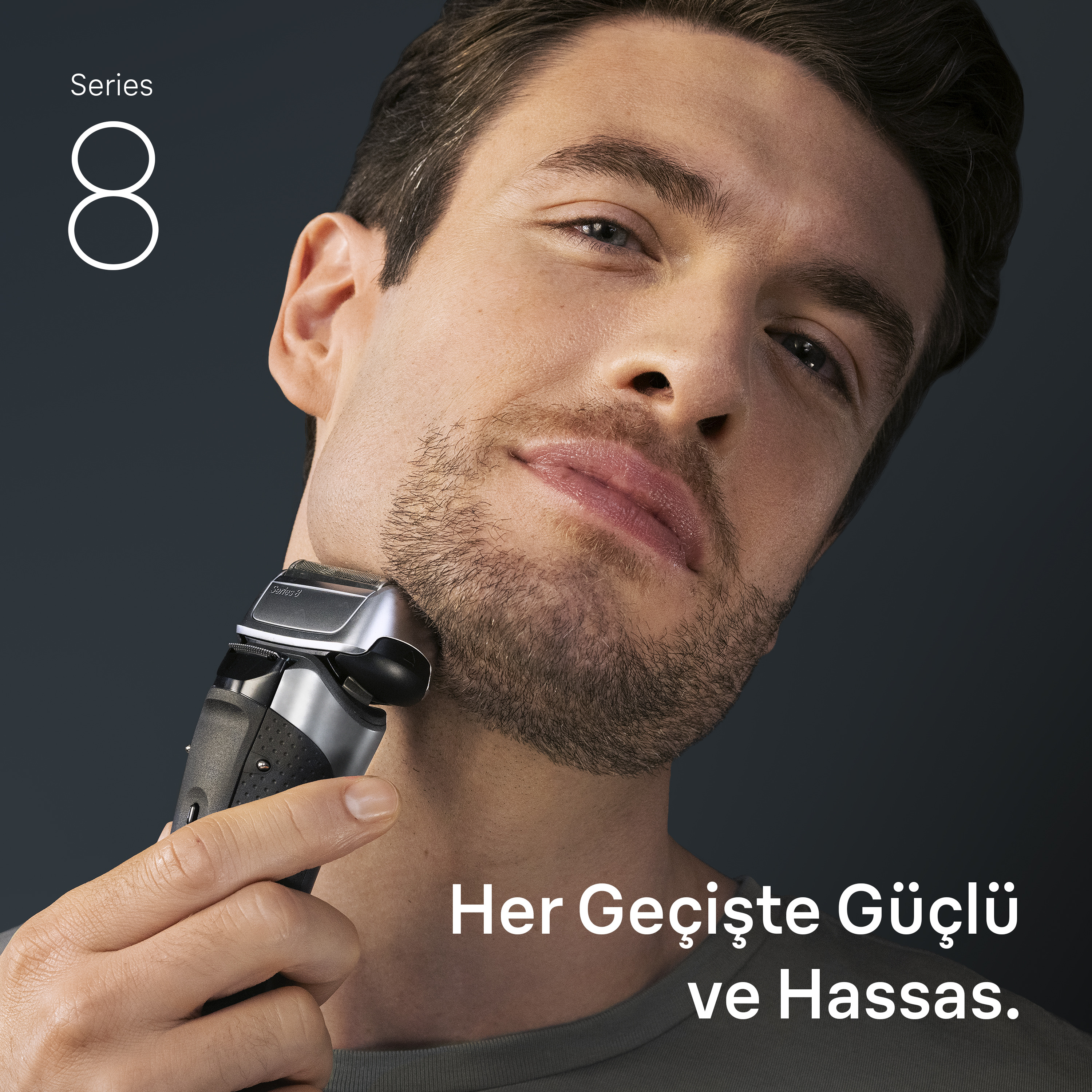 Adam, elektrikli tıraş makinesiyle sakal tıraşı oluyor. Koyu arka plan, metin: 'Her Geçişte Güçlü ve Hassas'.
