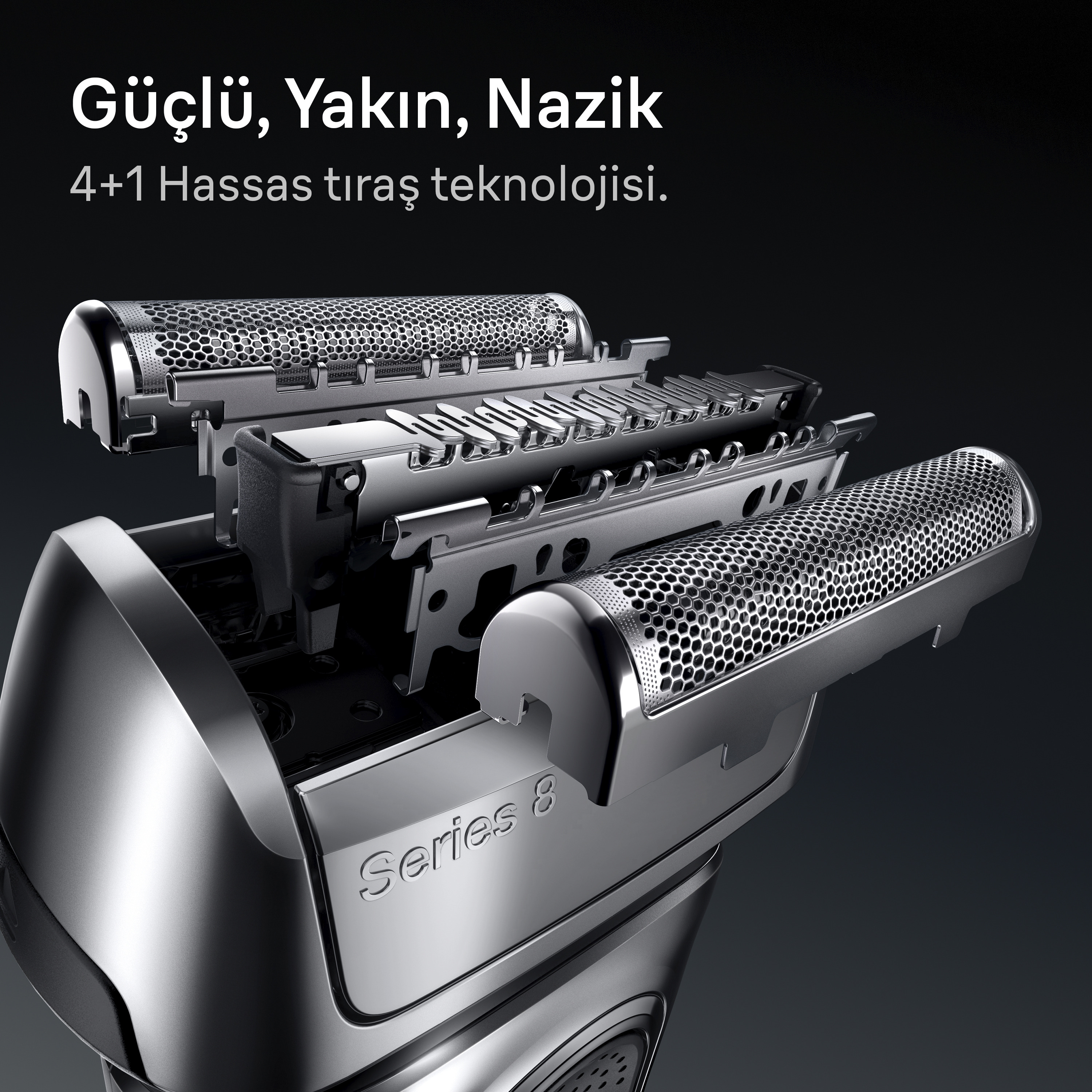Gümüş renkli bir elektrikli tıraş makinesinin, bıçaklarını ve tasarımını vurgulayan yakın çekimi. Metin şöyledir: 'Güçlü, Yakın, Nazik'.
