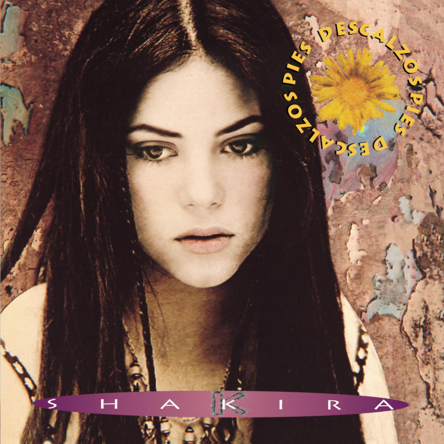 Shakiras Albumcover. Sie hat lange, dunkle Haare und schaut den Betrachter an. Text: Descalzos, Shakira und eine gelbe Blume.