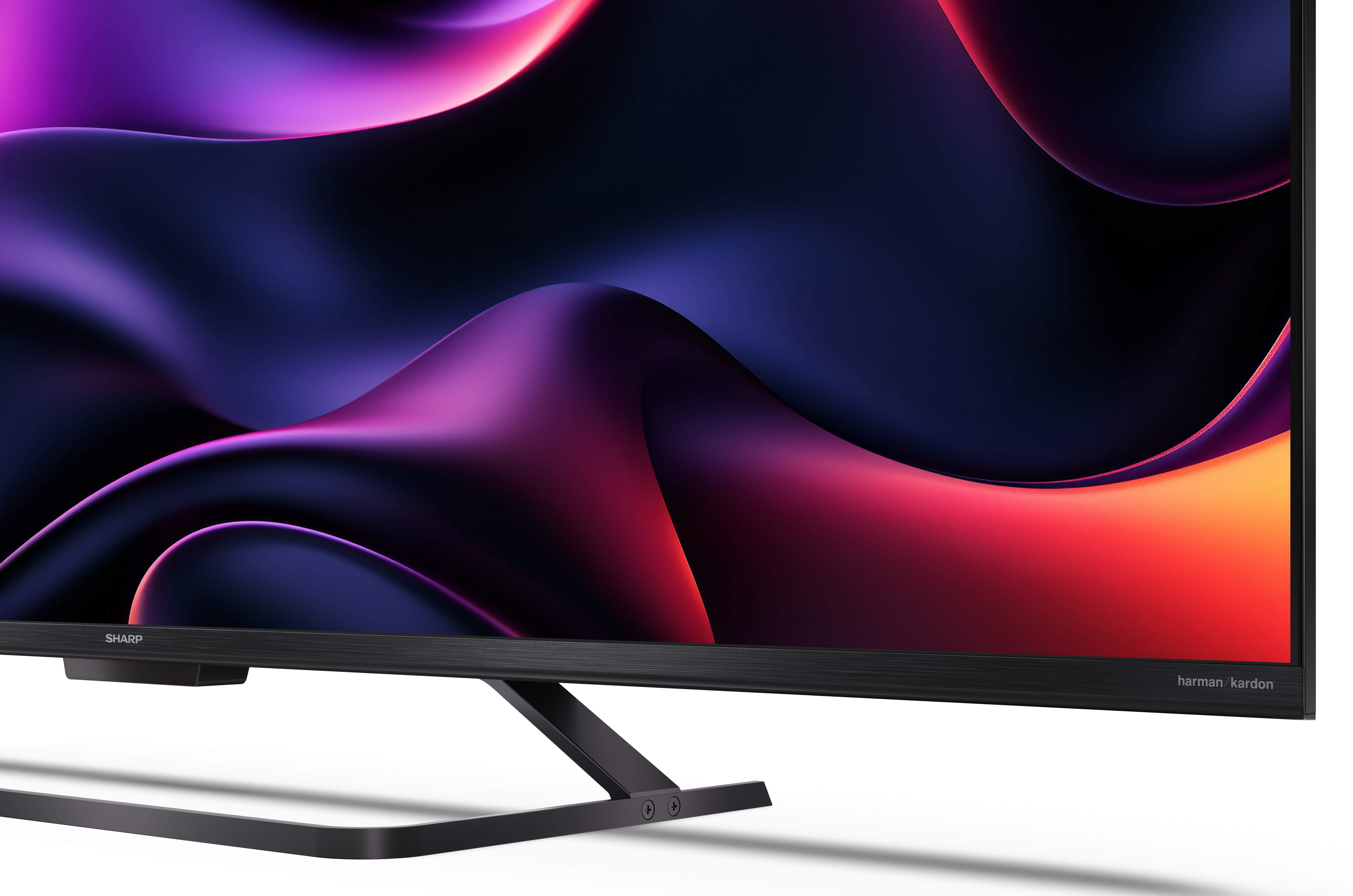 Nowoczesny telewizor z czarną ramą, wyświetlający abstrakcyjny wzór w odcieniach fioletu, czerwieni i pomarańczy. Stojak jest również czarny.