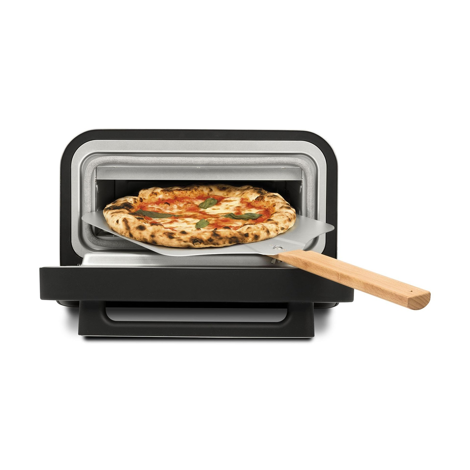 Una pizza cuoce in un piccolo forno nero. Una pala per pizza con manico in legno esce dal forno.