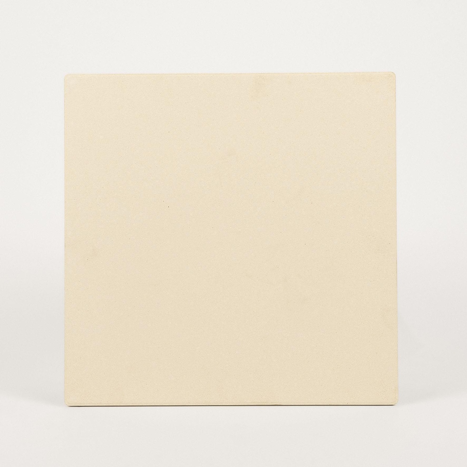 Un oggetto quadrato beige chiaro è centrato su uno sfondo bianco. L'oggetto ha angoli arrotondati e una superficie strutturata.