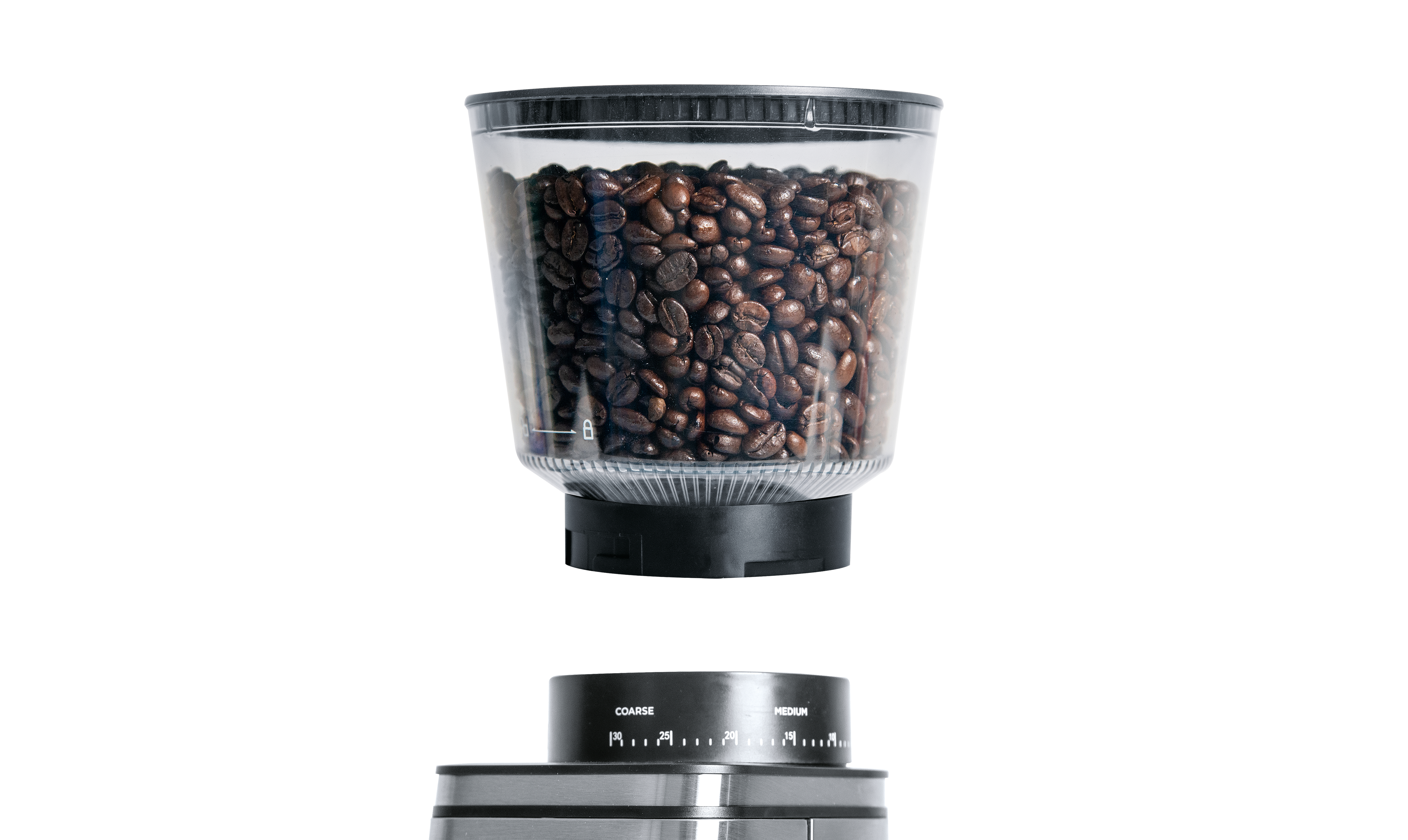 Eine Kaffeemühle mit einem transparenten Behälter voller Kaffeebohnen über dem Mahleinstellungsrad. Weißer Hintergrund.