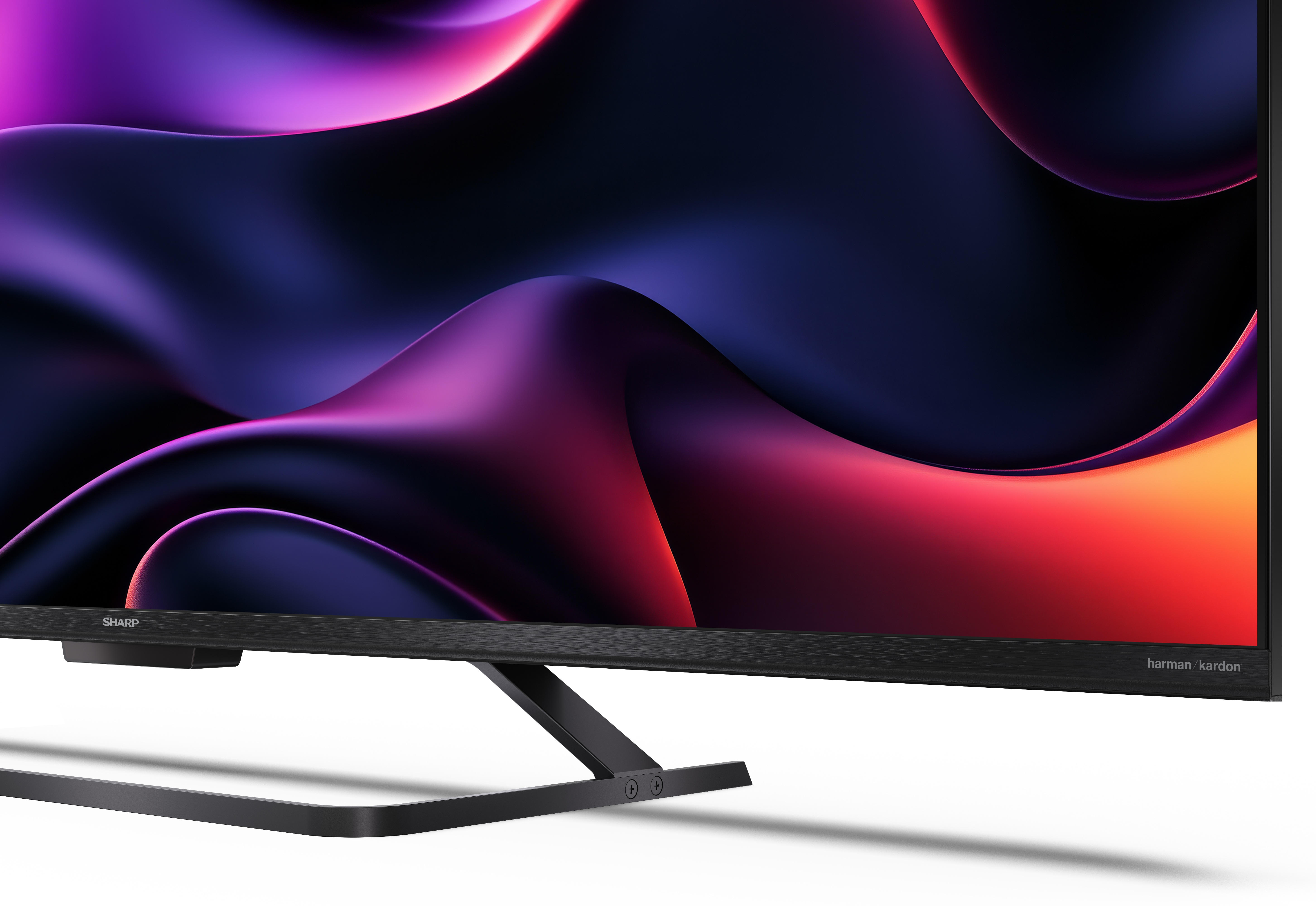 Telewizor Sharp wyświetla kolorowy, abstrakcyjny obraz. Telewizor ma czarną ramę i stojak.