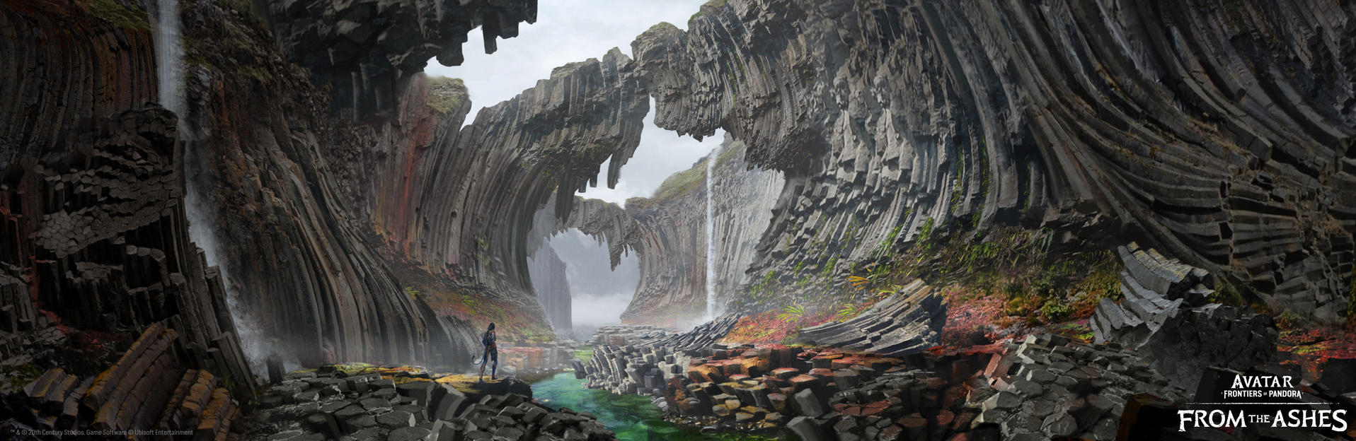 Eine Person steht in einer Schlucht mit Wasserfällen. Felsformationen rahmen die Szene ein. Das Wasser ist grün. Der Himmel ist bewölkt.