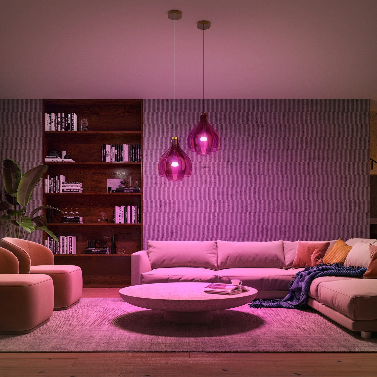 Pink-lit living room with sofa, chairs, coffee table, bookshelves, and hanging lights. A rug and plants add detail to the scene.