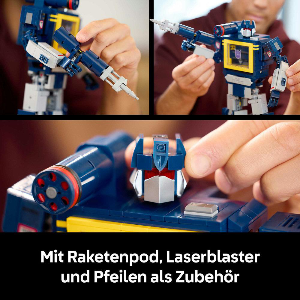 Ein blau-weißes Roboterspielzeug wird zusammengebaut. Zu den Teilen gehören ein Kopf, ein Blaster und ein Raketenpod. Der Hintergrund zeigt eine Person.