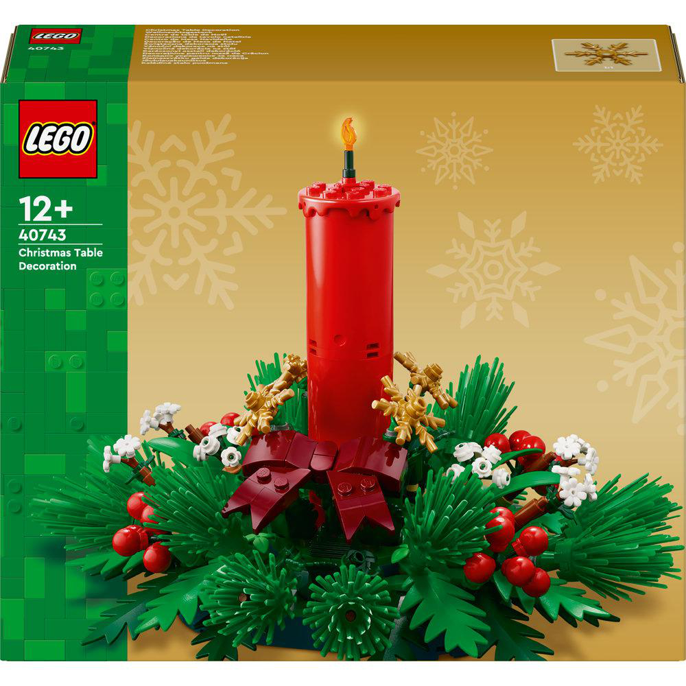 LEGO-Weihnachtstischdekoration. Eine große rote Kerze mit Flamme, umgeben von grünen, roten und weißen Dekorationen, auf goldenem Hintergrund.