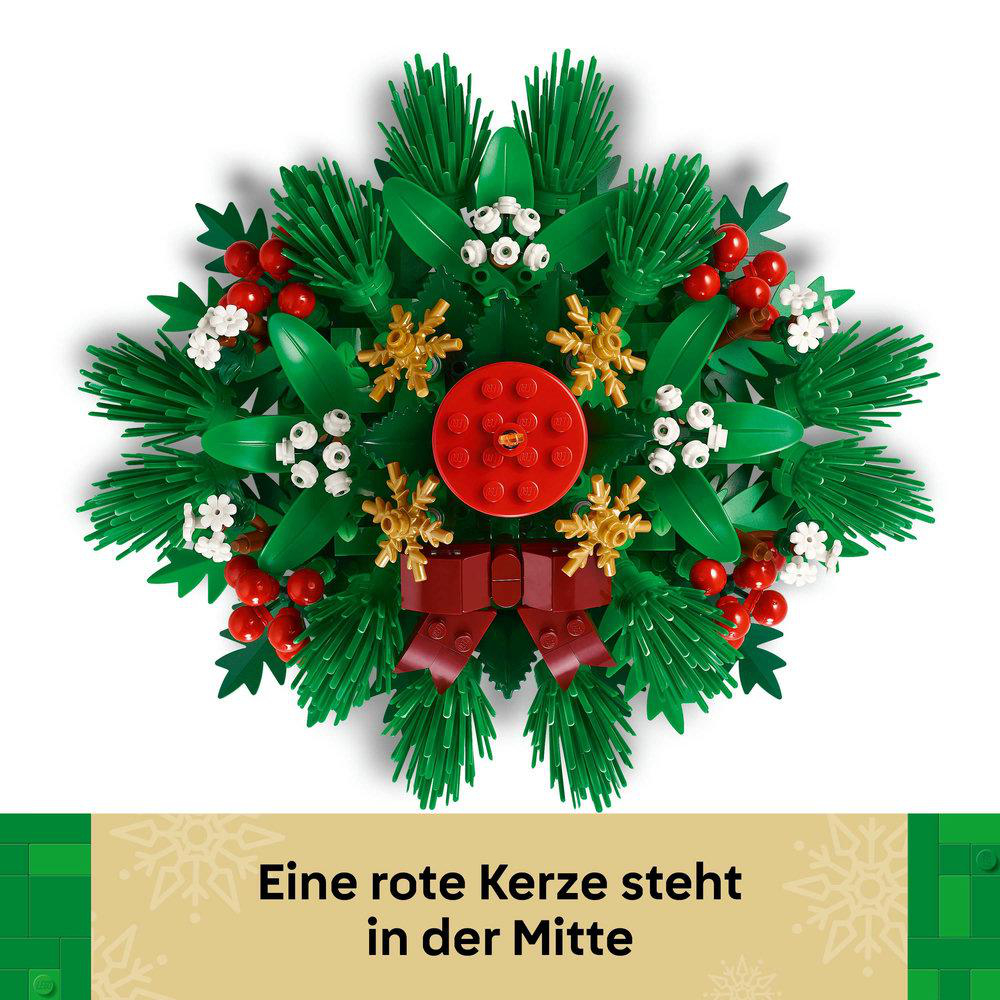 Ein Lego-Weihnachtskranz mit roten Beeren, grünen Blättern, goldenen Schneeflocken und einer roten Schleife. In der Mitte steht eine rote Kerze.