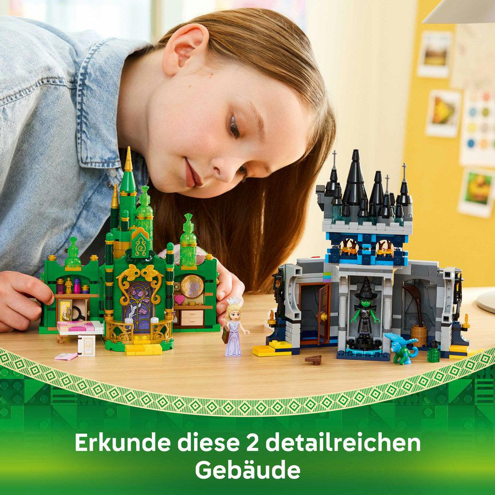 Ein Mädchen betrachtet zwei Lego-Schlösser. Eines ist grün, das andere grau. Eine Hexenfigur und ein kleiner blauer Drache sind zu sehen.