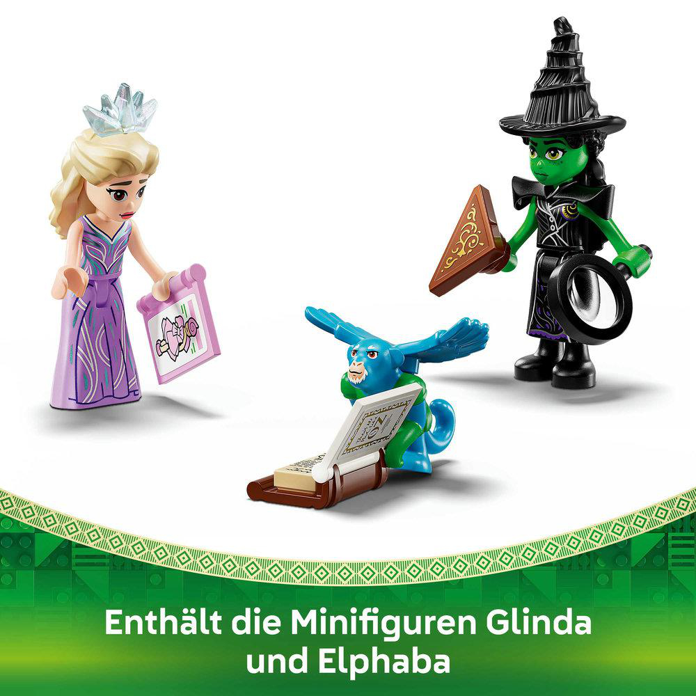 Lego-Figuren: Glinda mit Krone, Elphaba in schwarzem Hexenoutfit und ein blauer Affe liest ein Buch.