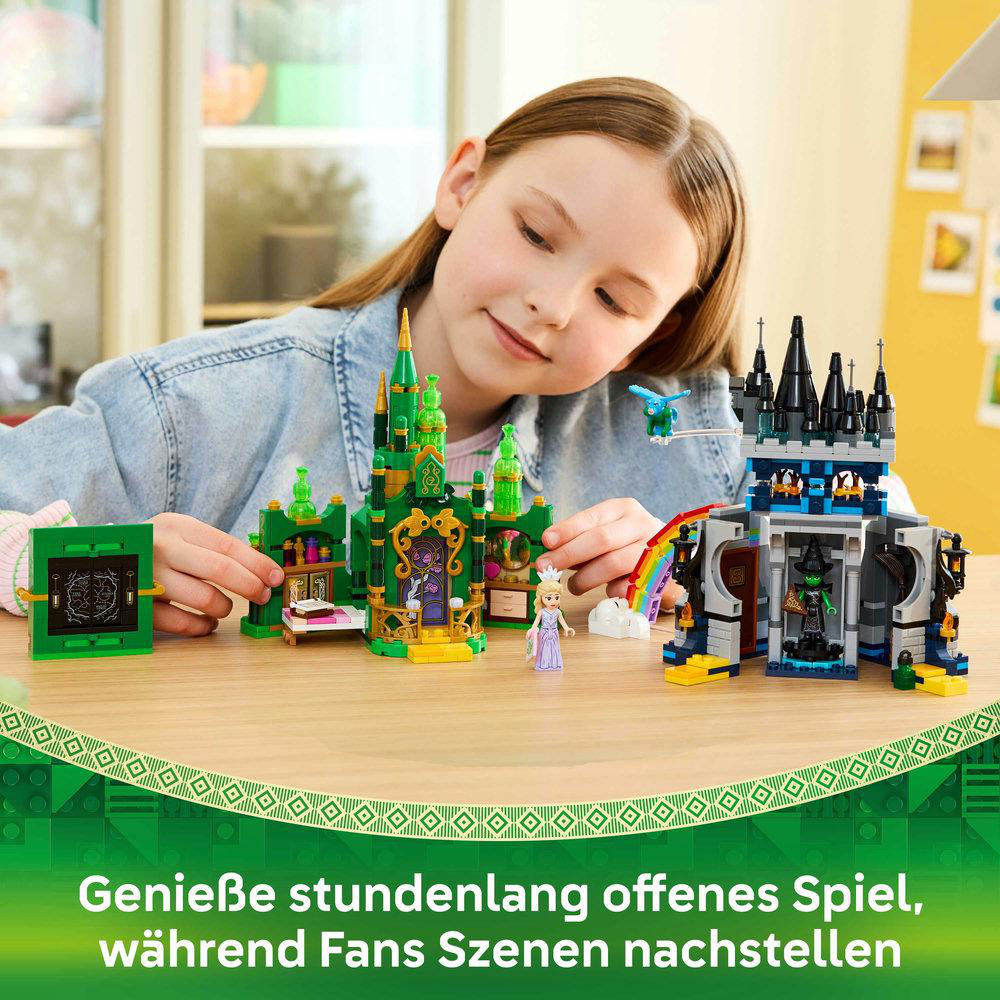 Ein Mädchen spielt mit Lego-Burgen auf einem Tisch. Die Sets umfassen eine grüne Burg, eine schwarze Burg und einen Regenbogen.