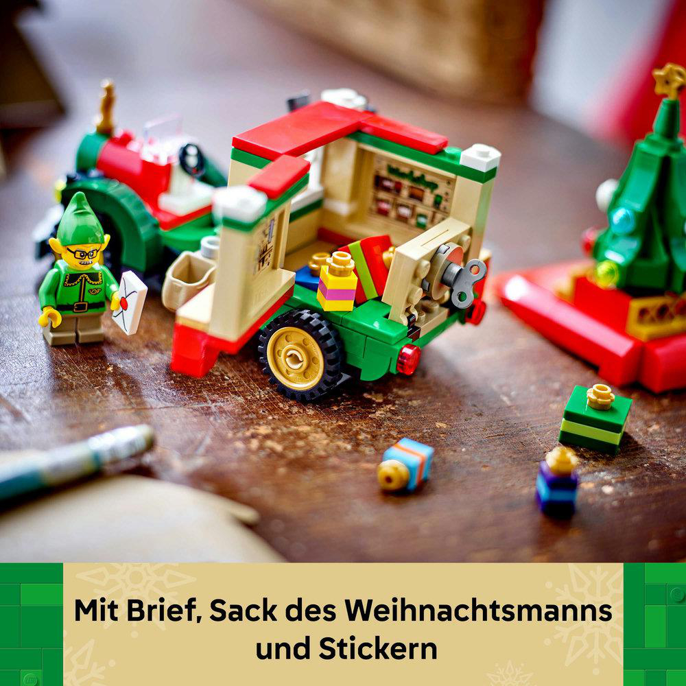 Eine Lego-Weihnachtsszene mit einem Elf, einem Fahrzeug, einem Weihnachtsbaum und Geschenken auf Holz.