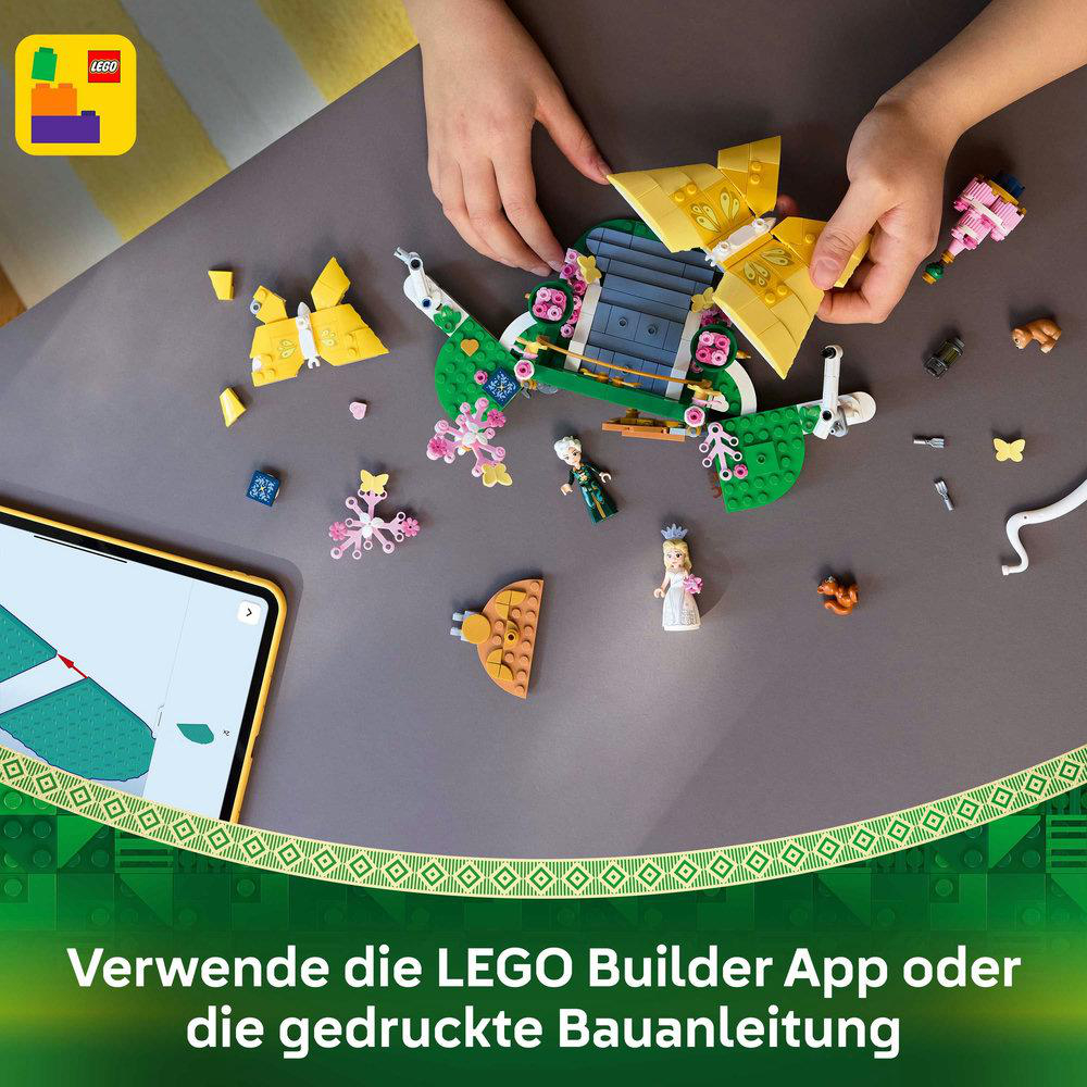 Hände setzen LEGO-Set mit gelben und grünen Teilen zusammen. Verschiedene LEGO-Elemente und ein Tablet liegen auf dem Tisch.