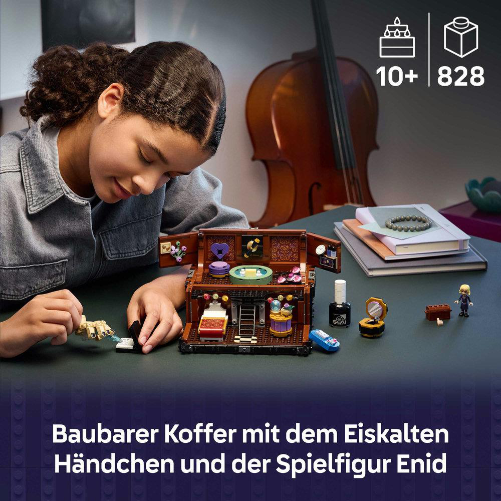 Ein Mädchen spielt mit einem Lego-Set mit einer braunen Truhe und Zubehör. Ein Cello und Bücher sind im Hintergrund.