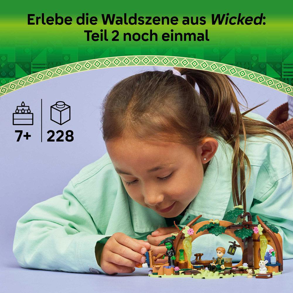 Ein Mädchen betrachtet ein Lego-Set mit einer Waldszene. Das Set enthält Lego-Figuren, eine Hütte und Zubehör.