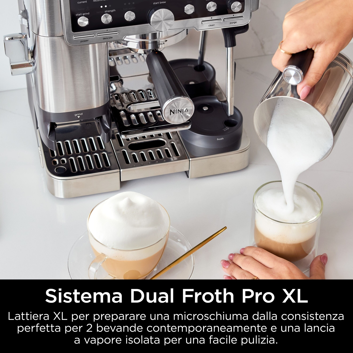 Una persona versa la schiuma di latte da una caraffa in un bicchiere di caffè. A sinistra una macchina per l'espresso, a destra un cappuccino.