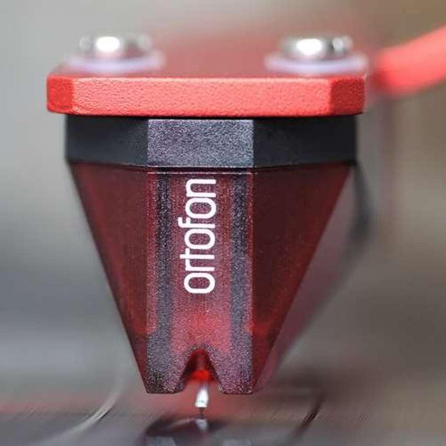Primo piano di una testina Ortofon rossa con stilo. La testina ha una sezione nera e una parte superiore rossa.