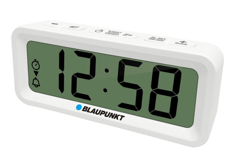 Biały cyfrowy budzik Blaupunkt pokazuje 12:58 na zielonym wyświetlaczu. Przyciski są oznaczone 'SET', 'AL SET' i 'MODE'.