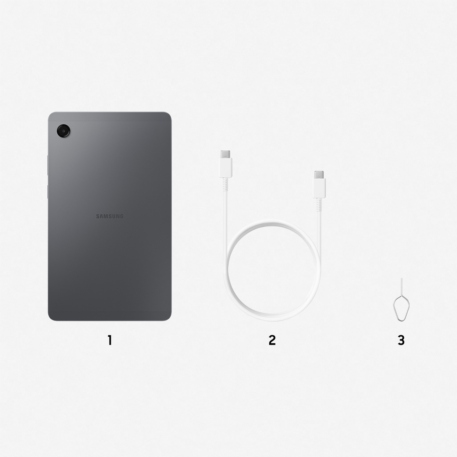 Une tablette grise, un câble de charge blanc et un outil d'éjection SIM sont disposés sur fond blanc. La tablette porte l'inscription 'SAMSUNG'.