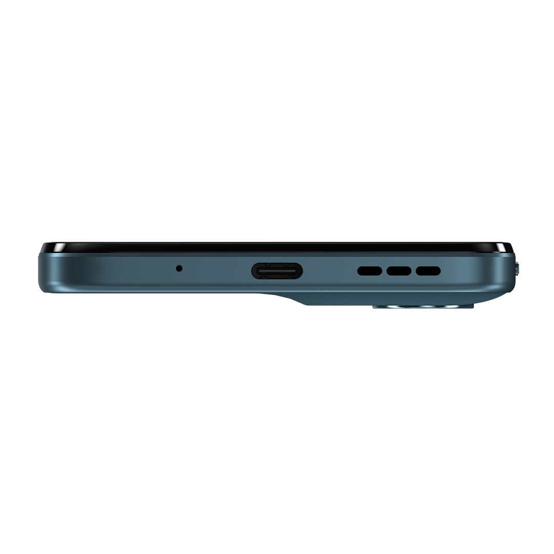 Egy türkiz okostelefon alsó szélének közeli képe, USB-C porttal, mikrofonnyílással és hangszórórácsokkal fehér háttéren.